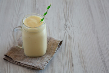 Homemade Pineapple Mango Banana Smoothie in a Glass Jar, side view. Copy space.