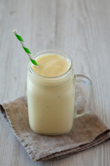 Homemade Pineapple Mango Banana Smoothie in a Glass Jar, side view. Space for text.