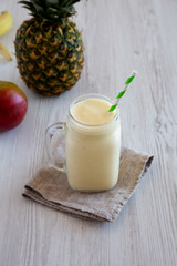 Homemade Pineapple Mango Banana Smoothie in a Glass Jar, side view.