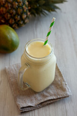 Homemade Pineapple Mango Banana Smoothie in a Glass Jar, low angle view.