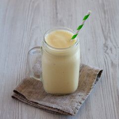 Homemade Pineapple Mango Banana Smoothie in a Glass Jar, side view.