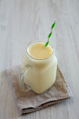 Obraz na płótnie Canvas Homemade Pineapple Mango Banana Smoothie in a Glass Jar, side view.