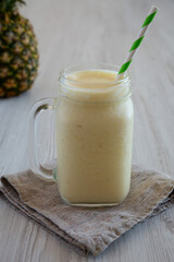 Homemade Pineapple Mango Banana Smoothie in a Glass Jar, side view.