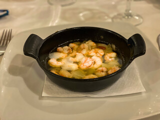 Iron pan with oil, garlic and shrimp