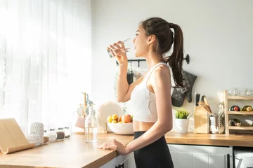 Fotobehang Asian beautiful woman in sportswear drink water after exercise at home © Kawee