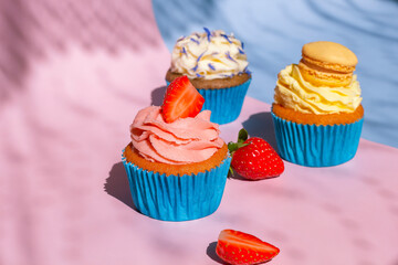 cupcakes with cream on cute blue and rosy background. food postcard