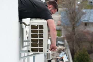 the worker connecting a new air conditioner unit