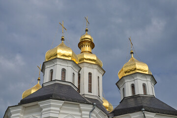 Fototapeta na wymiar Gilded domes of an ancient Orthodox church against the sky.