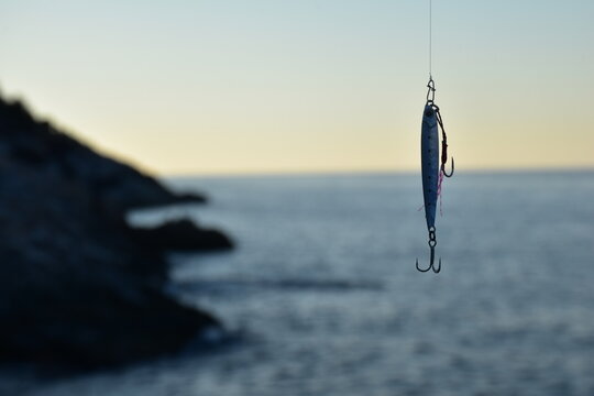 Metal fishing lure and a blur sea background