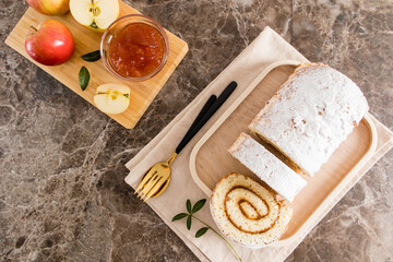 top view of a delicious dessert. apple roll sprinkled with powdered sugar on a wooden tray. homemade cakes.