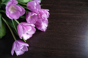 Training, master classes and floristry courses making a bouquet. Beautiful romantic bouquet of pink tulips on a wooden background for your text.