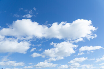 Fototapeta na wymiar Blurred white clouds against the blue sky. Heavenly natural background. Clouds run across the sky.
