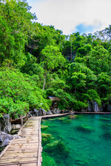 Kayangan Lake - Blue crystal water in paradise lagoon - walkway on wooden pier in tropical scenery - Coron island, Palawan, Philippines.
