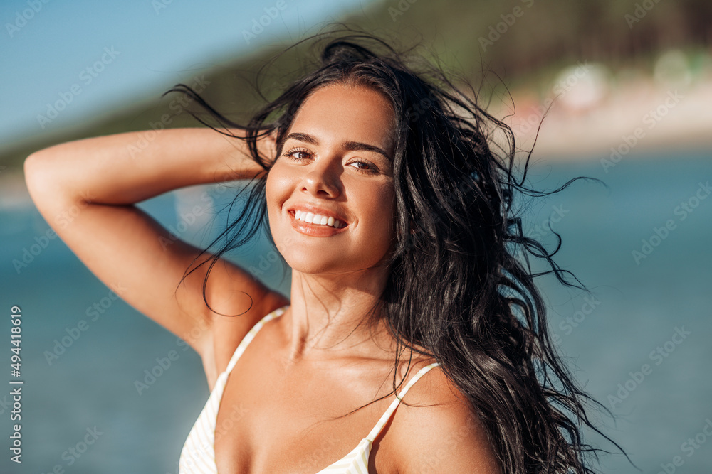 Poster people, summer and swimwear concept - happy smiling young woman in bikini swimsuit on beach