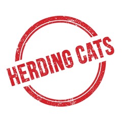 HERDING CATS text written on red grungy round stamp.