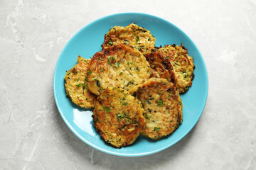 Delicious zucchini pancakes on grey table, top view