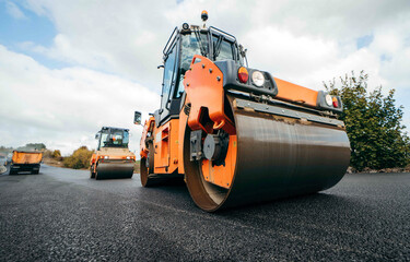 Vibratory asphalt rollers compactor compacting new asphalt pavement. Road service repairs the highway	
