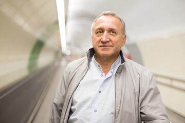 Fototapeta premium Middle aged man on moving walkway