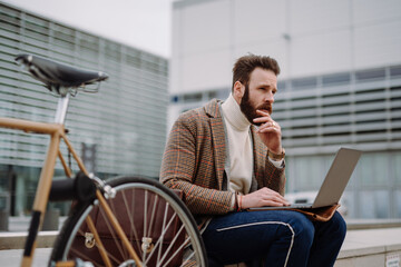 Contemplative businessman sitting outside and thinking about solving problem. Remote work