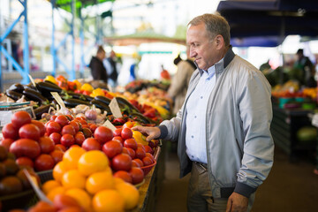 Man purchasing peppers in greengrocery