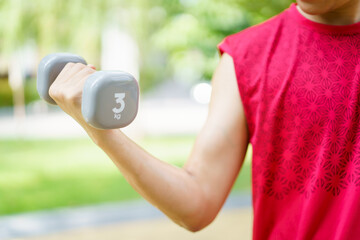 Active Asian young man doing a weightlifting by using dumbbell, beginner muscular bodybuilder.