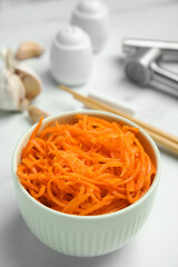 Delicious Korean carrot salad in bowl on white table