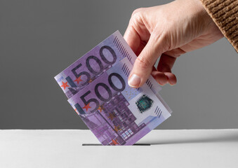 charity, financial support and saving concept - close up of hand putting money into donation box
