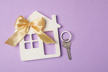 House model with bow and key on violet background, flat lay. Housewarming party
