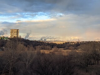 Naklejka premium view of the smoking factories, workshops. Metallurgy. Sunset. Gray sky with smog. Ecological problem