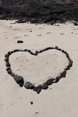 Heart shape in the beach made with volcanic stones
