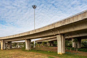 Fototapeta na wymiar Grass under the overpass,Freeway, overpass and junction with green grass