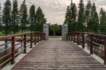 Obraz premium Wooden bridge over little river in city park