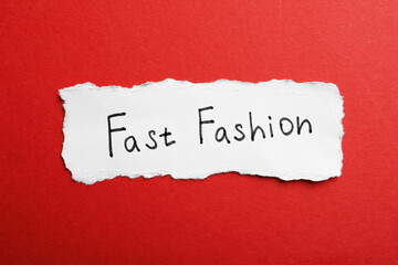 Torn piece of paper with phrase Fast Fashion on red background, top view