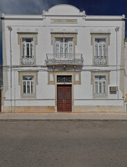 Neoclassical house-white facade-metal railing-balcony and balconets-closed door and windows....