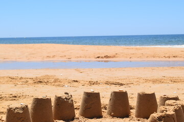 Handmade sand sculpture at the beach on a sunny day in vacation time with the blue ocean in the background