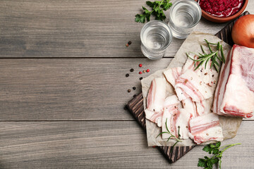 Tasty salt pork with rosemary and spices on wooden table, flat lay. Space for text