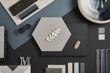 Flat lay of stylish architect moodboard composition with black, beige and grey samples of textile, paint, panels and tiles. Top view. Copy space. Template.