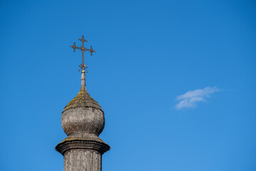 Wooden dome with orthodox cross of ancient ukrainian church against the blue sky in Kyiv, Ukraine