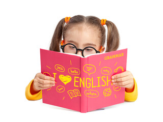 Beautiful cute little girl with glasses reading English grammar book in front of white background....