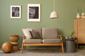 Stylish living room interior composition. Modern scandi sofa,  mock up frames, wooden commode and creative personal accessories. Eucalyptus green wall. Template. Copy space.