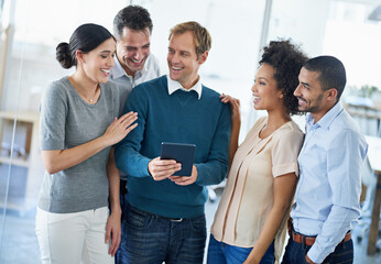 Id love to hear your input. Shot of a group of diverse colleagues using a digital tablet while standing in an office.