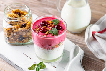 Yogurt, cherry smoothie, homemade granola and frozen cherries. Healthy breakfast or snack