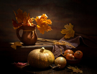 Fototapeta na wymiar Pumpkin and onion on a dark background with autumn leaves