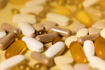 A lot of pills on a yellow background.