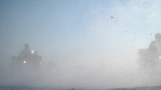 atv-riders drive through the snow
