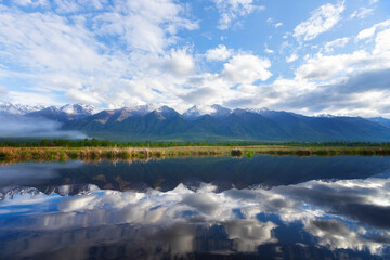Landscape with mountains reflecting in the water on summer day. Buryatia, Tunkinskaya valley