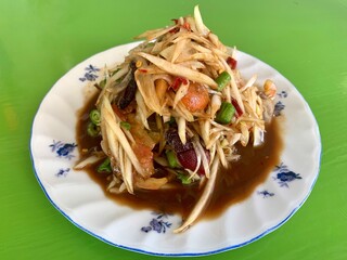 Top view spicy papaya salad (Som Tum) Thai traditional food isolated on green  background.