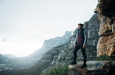 This is where you find out who you are. Shot of a young man standing on a cliff while out on a hike.