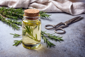 Glass jar of oil with fresh rosemary spice for tasty meals