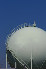 青空とガスタンクを望遠で写す。ガスタンクの球体と階段は、まるでコンビナートの様です。Take a telephoto shot of the blue sky and the gas tank. The sphere and stairs of the gas tank are like a complex.